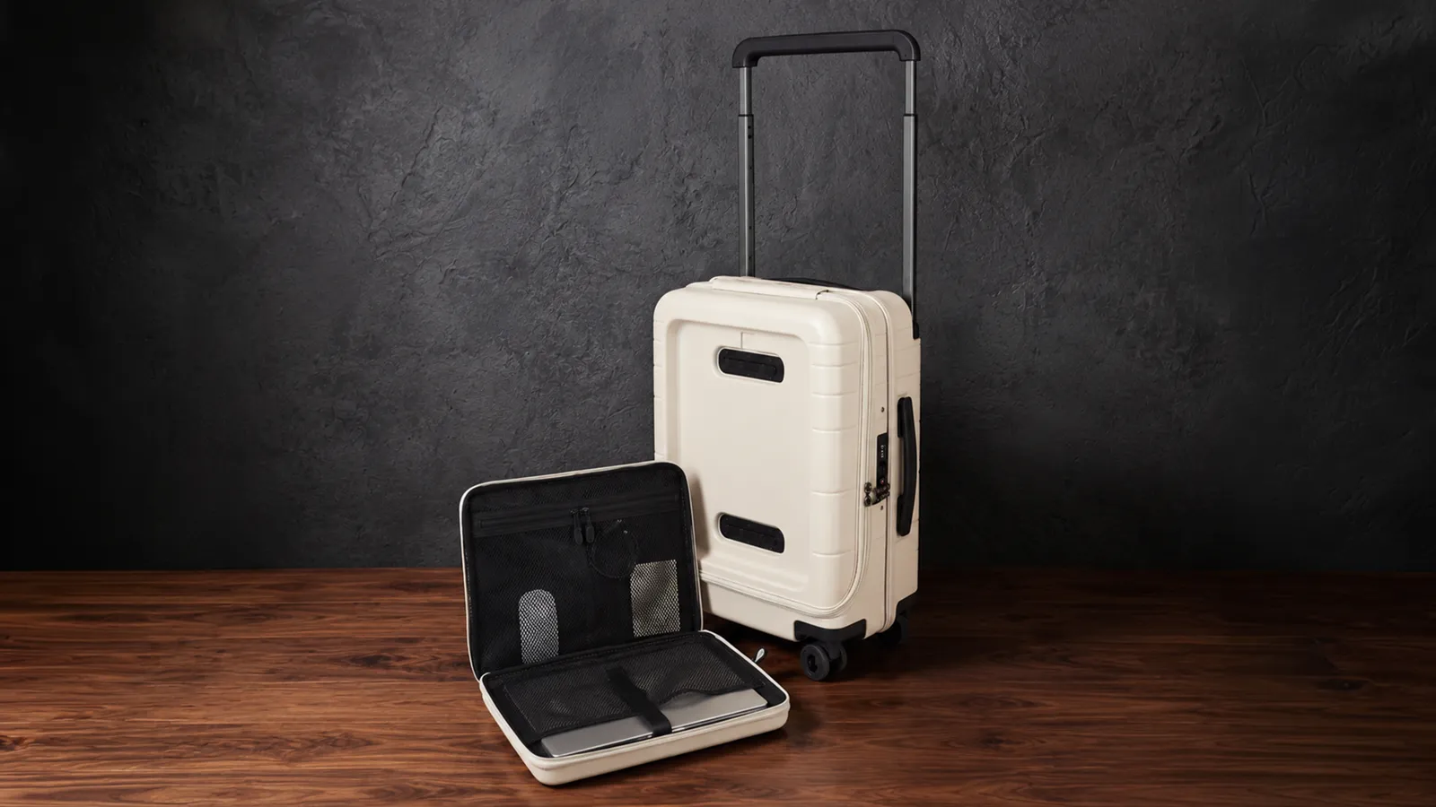 The carry-on standing beside its removable laptop sleeve kit, laid open on the floor.