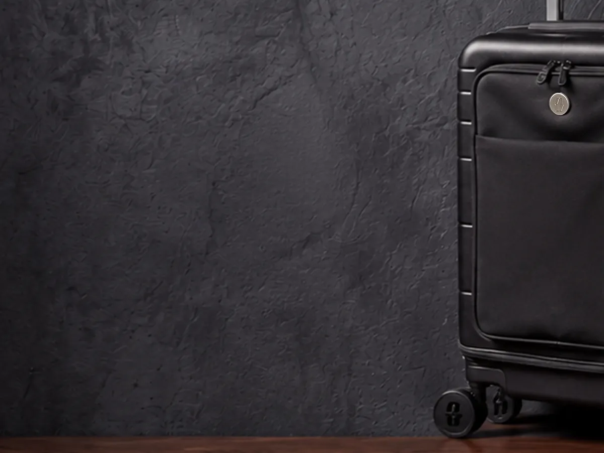 The Vasy carry-on in midnight black on the dark studio set.
